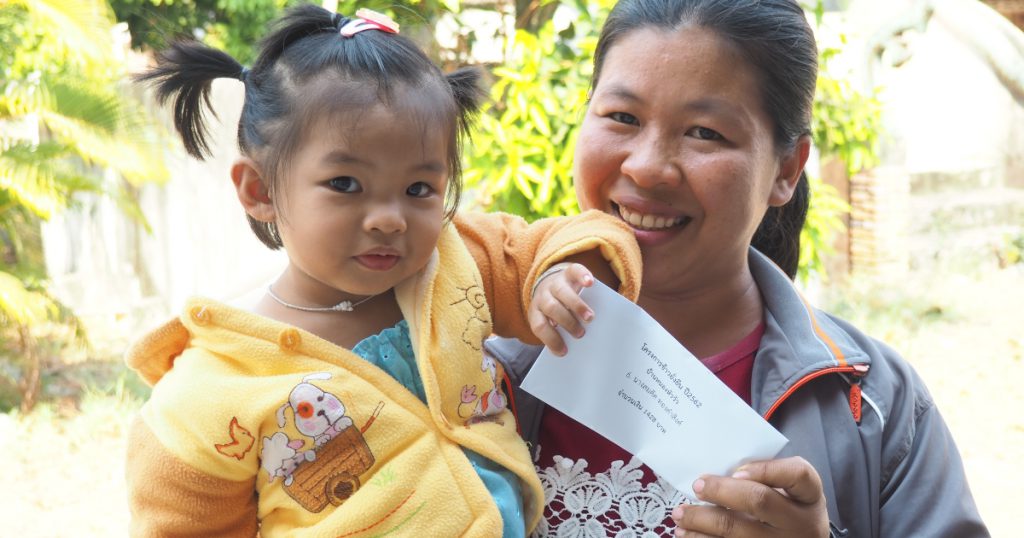 A farmer from Samrong district of Ubon Ratchathani province takes her daughter to the community hall, so they can receive the bonus together. (Photo credit: GIZ Thailand)